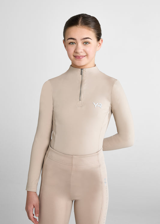 Person wearing a beige long-sleeve top with a zipper and matching pants on a light gray background