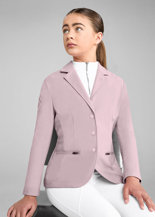 Woman wearing a light pink equestrian jacket on a gray background