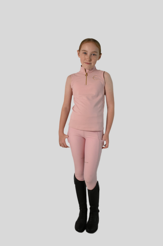 Person wearing a pink equestrian outfit with black boots on a white background