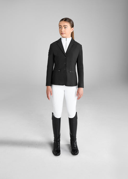 Person wearing a black equestrian jacket, white pants, and black boots on a gray background